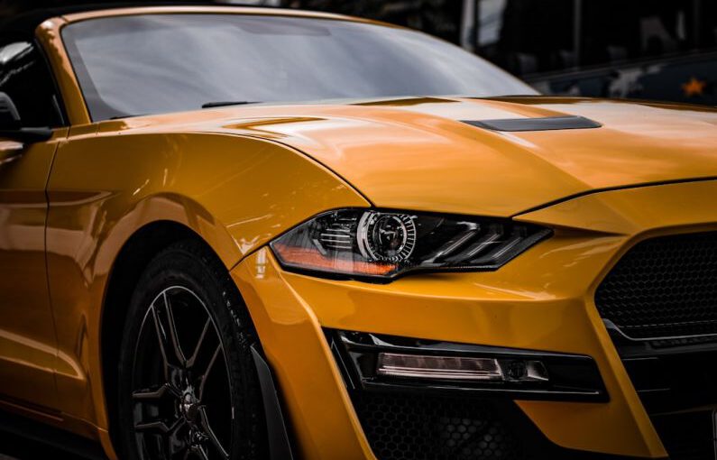 Mustang Auto - a close up of the front of a yellow sports car