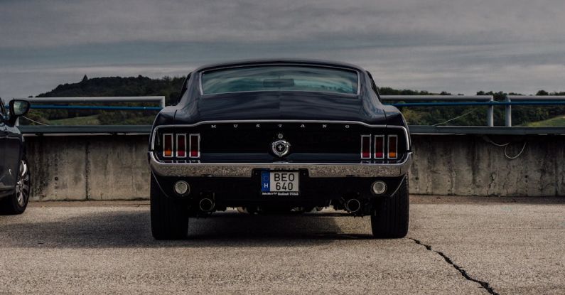 Mustang Auto - Black Ford Mustang on the Concrete Car Park