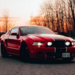 Mustang Auto - Red Sports Car on the Asphalt Road During Sunset