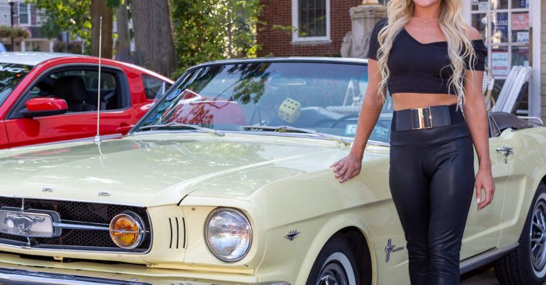 Mustang Auto - A Woman Standing Beside a Sports Car